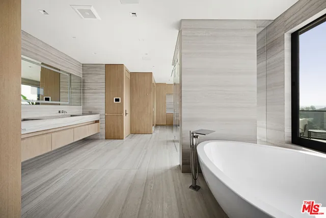 a spacious bathroom with a double vanity sink a mirror and a bathtub