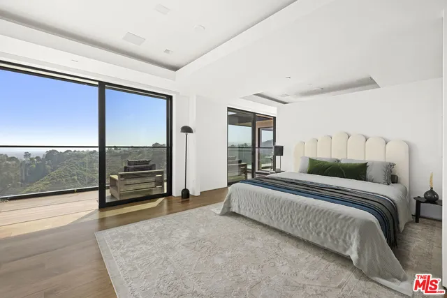 a spacious bedroom with a bed and large windows