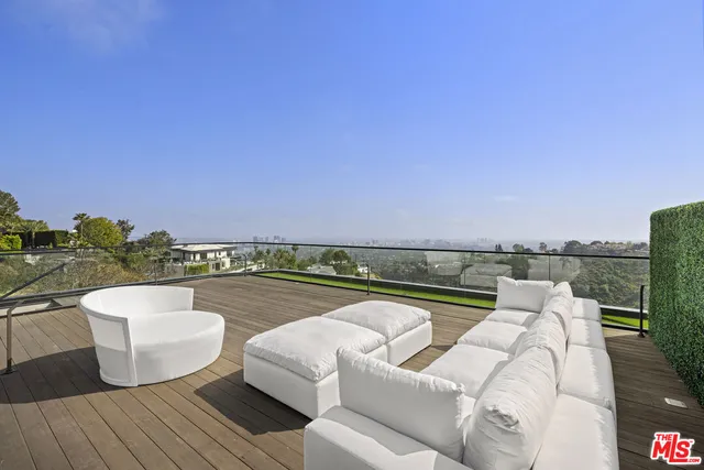a view of roof deck with couches and sky view