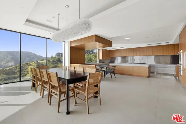 a view of a dining room with furniture a chandelier and a large window