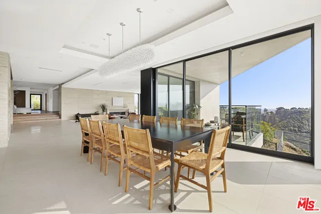 a dining room with furniture and a floor to ceiling window