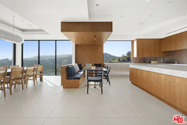 a living room with stainless steel appliances kitchen island granite countertop furniture and a large window