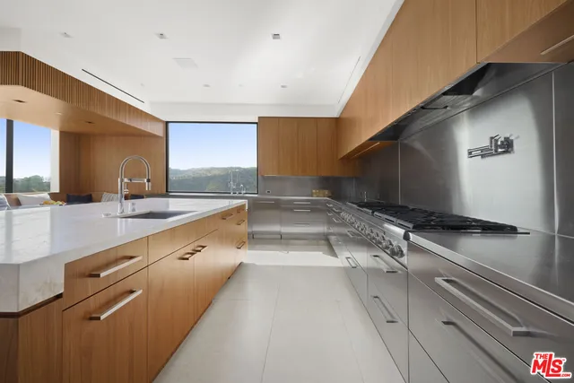a large kitchen with kitchen island granite countertop a sink and stainless steel appliances