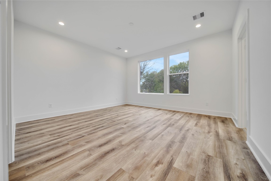 7709 Inwood Grove Lane Houston, TX 77088 - Photo 17 of 36 an empty room with wooden floor and windows