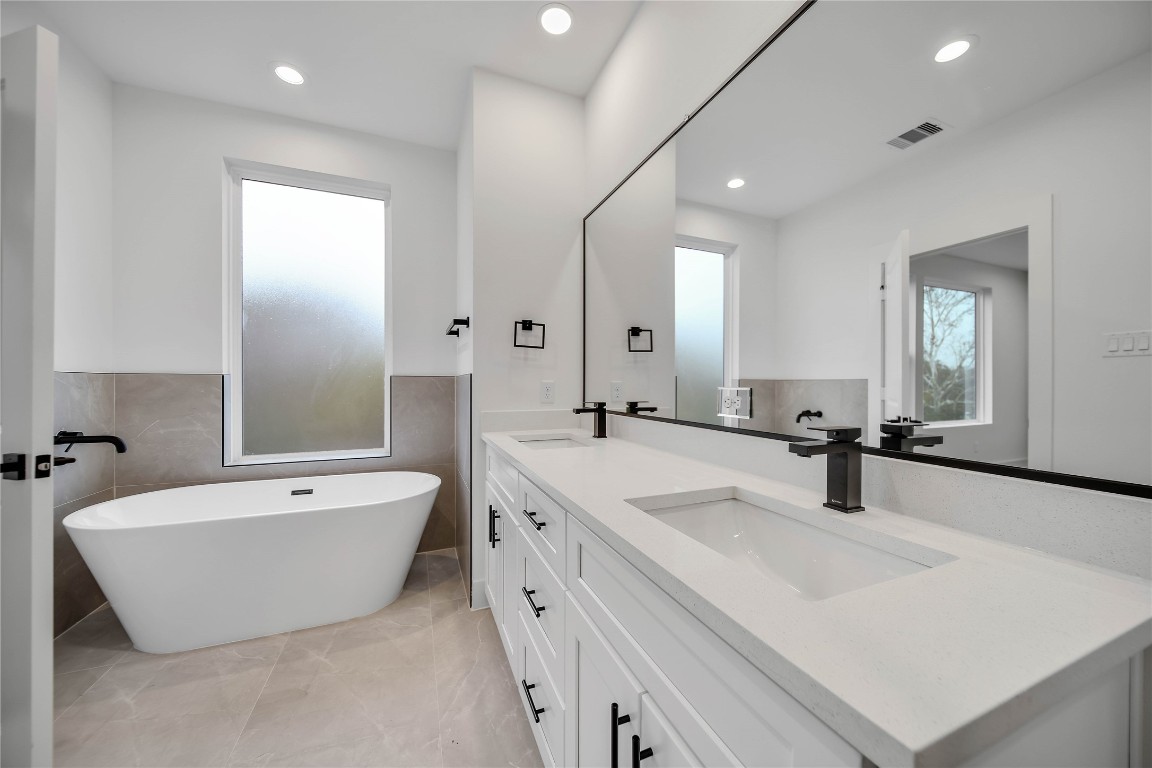 7709 Inwood Grove Lane Houston, TX 77088 - Photo 19 of 36 a bathroom with a double vanity sink mirror and bathtub