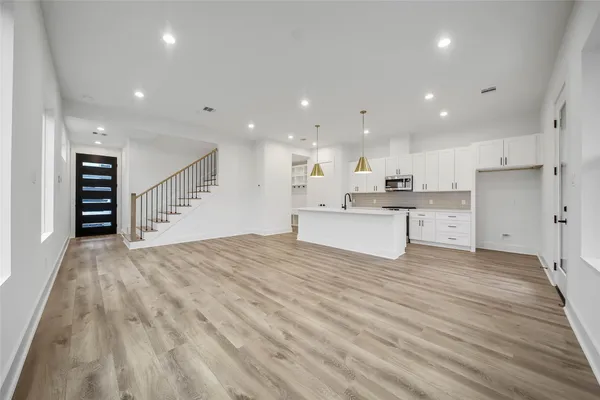 a large white kitchen with kitchen island a sink a stove and a refrigerator