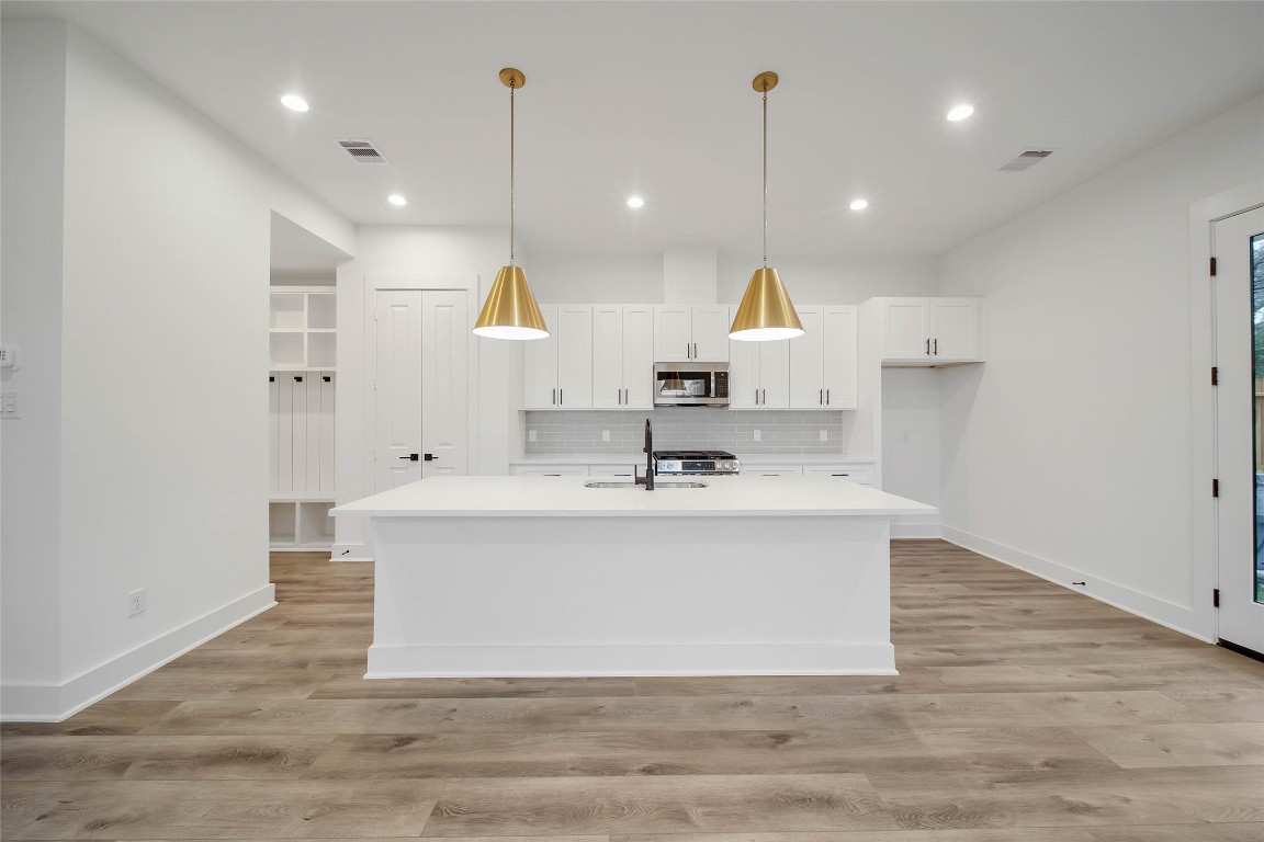 7709 Inwood Grove Lane Houston, TX 77088 - Photo 6 of 36 a view of a kitchen with kitchen island a sink stainless steel appliances and a fireplace