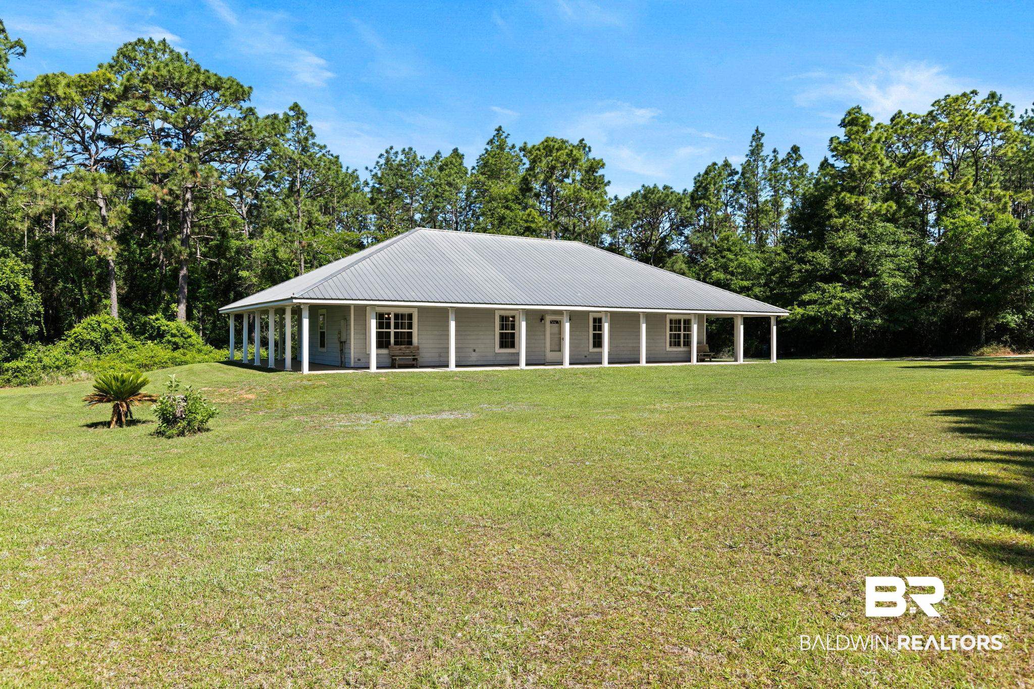 20219 Greek Cemetery Road Robertsdale, AL 36567 - Photo 3 of 41 Ranch-style residence featuring a metal roof and light-colored siding, surrounded by a expansive grassy area