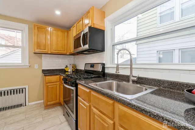 a kitchen with stainless steel appliances granite countertop a sink and a stove