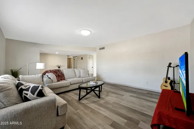 a living room with furniture and a wooden floor