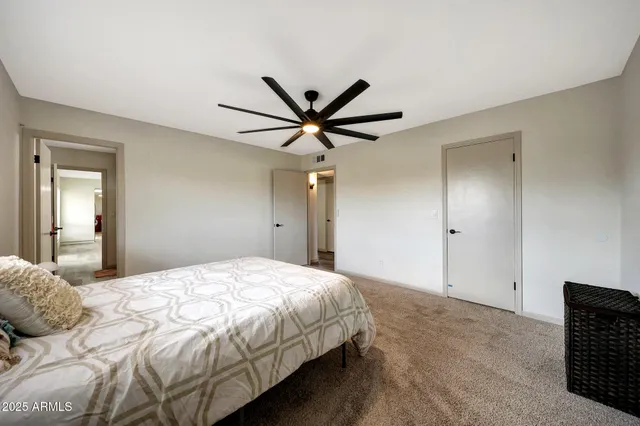 a bedroom with a bed and a ceiling fan