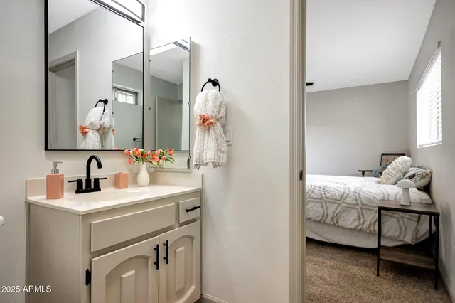 a en suite bathroom with a sink vanity and mirror