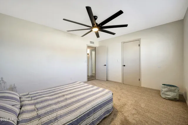 a bedroom with a bed and a ceiling fan