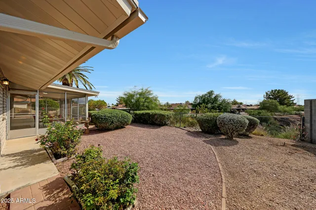 a view of a house with a yard and table under an umbrella