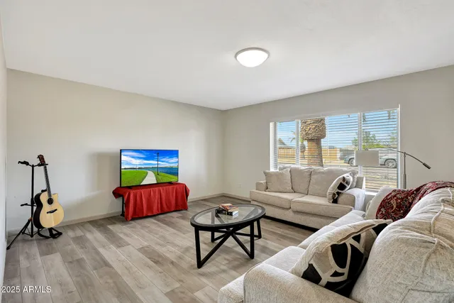 a living room with furniture a air conditioner vent and a window