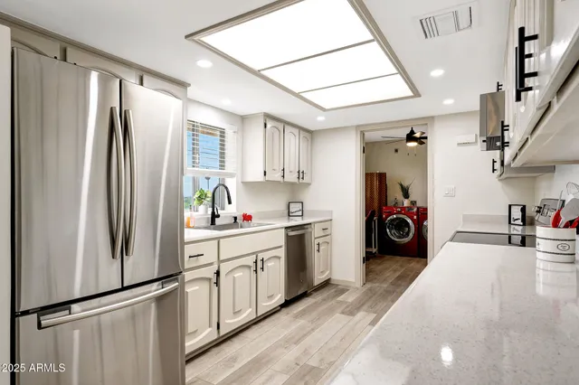 a kitchen with stainless steel appliances a refrigerator a sink a stove and cabinets