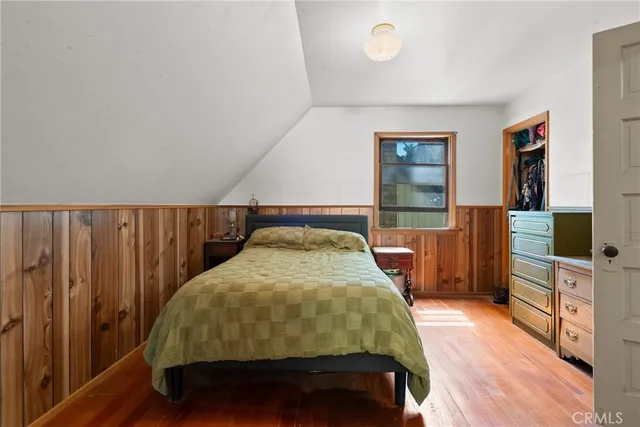a bedroom with a bed and a flat tv screen on dresser