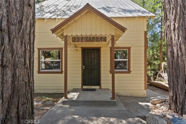 a view of a house with a wooden door and a large tree