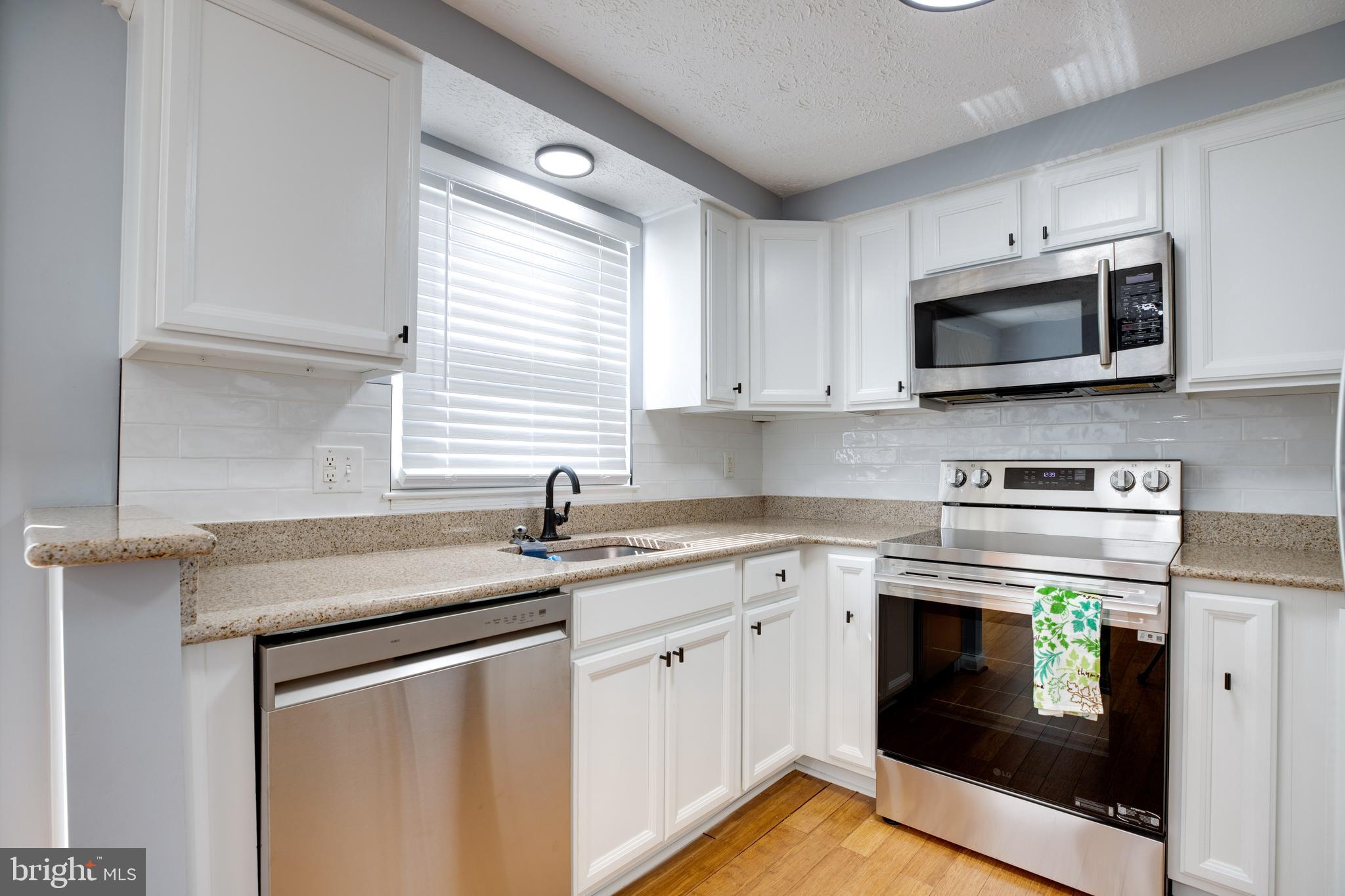 14609 Olde Kent Road Centreville, VA 20120 - Photo 12 of 33 a kitchen with stainless steel appliances granite countertop grey cabinets a stove a sink and a microwave