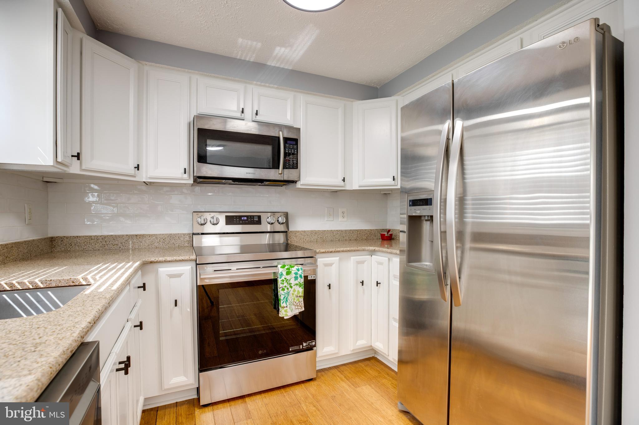 14609 Olde Kent Road Centreville, VA 20120 - Photo 13 of 33 a kitchen with stainless steel appliances granite countertop a refrigerator a stove and a sink