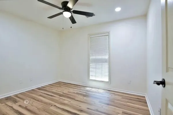 wooden floor in an empty room with a window