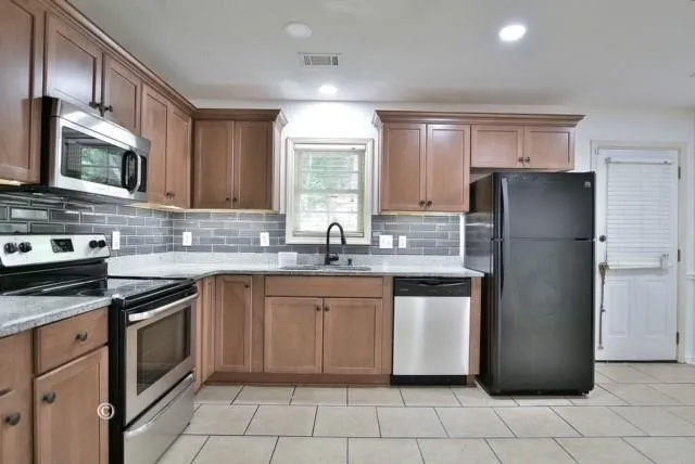 a kitchen with stainless steel appliances granite countertop a refrigerator stove a sink and dishwasher