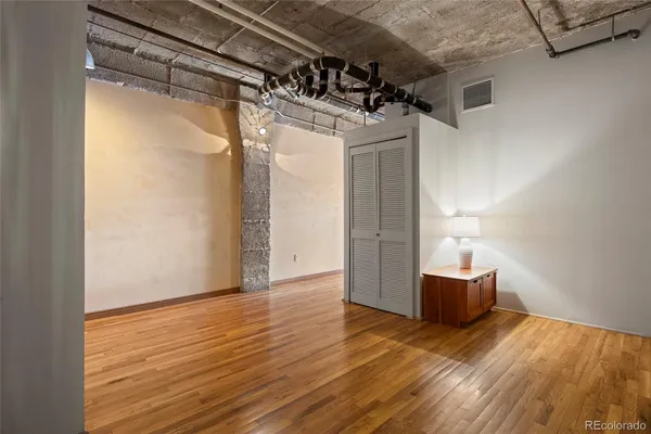 a view of empty room with wooden floor