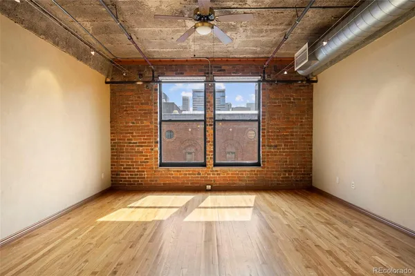 a view of a room with wooden floor and windows
