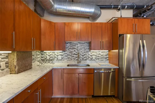 a kitchen with stainless steel appliances wooden cabinets and a refrigerator