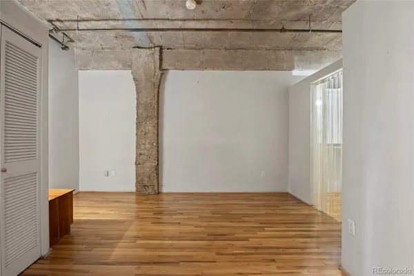 a view of a room with wooden floor and a window
