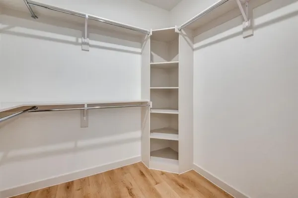 a view of walk in closet with empty racks