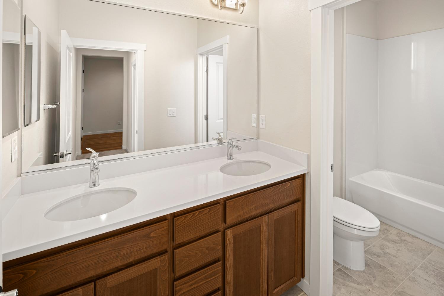 1727 Dos Rios Court Plumas Lake, CA 95961 - Photo 30 of 43 a bathroom with a granite countertop sink a toilet and bathtub