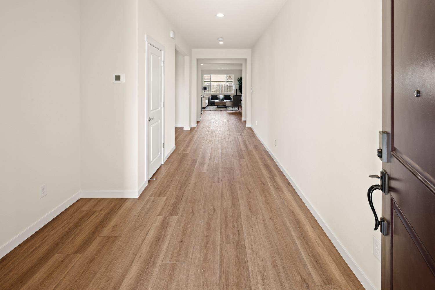 1727 Dos Rios Court Plumas Lake, CA 95961 - Photo 3 of 43 a view of a hallway with wooden floor and staircase