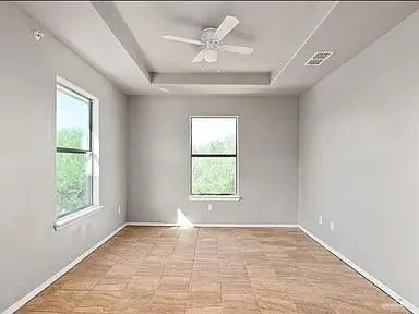 an empty room with a window and a fan