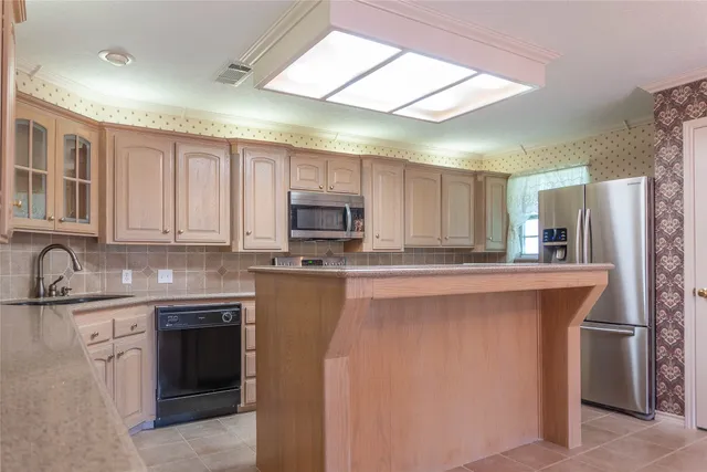 a kitchen with stainless steel appliances a sink stove refrigerator and cabinets