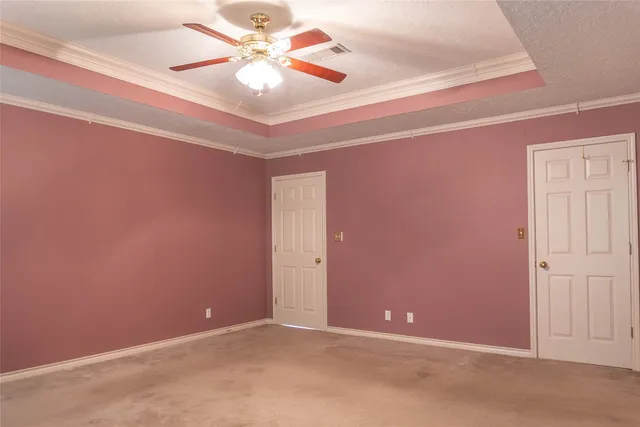 an empty room with windows and fan