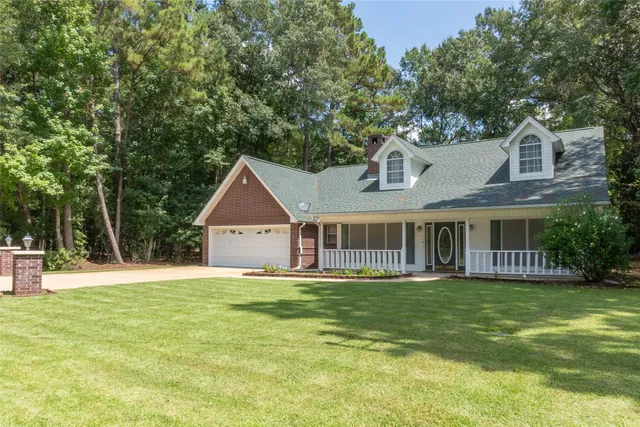 a front view of a house with a yard and trees