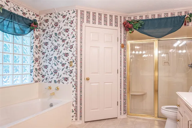 an empty room with chandelier fan and windows