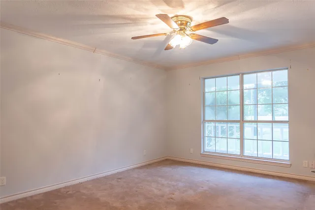 an empty room with chandelier fan
