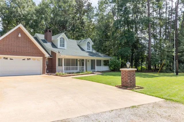a front view of a house with a yard and trees