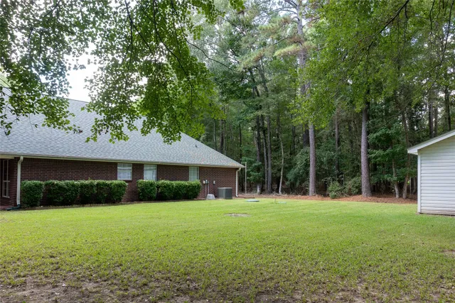 a view of house with backyard space and garden