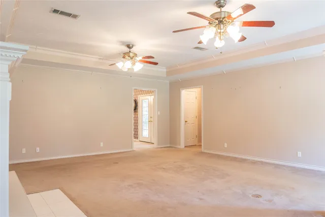 a view of an empty room with a chandelier fan