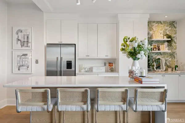 a kitchen with stainless steel appliances granite countertop a table chairs in it and wooden floor