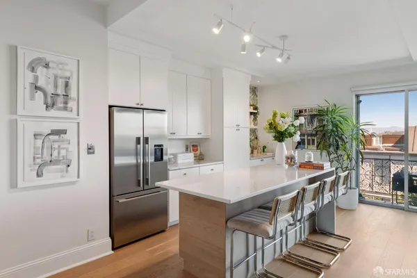 a kitchen with stainless steel appliances granite countertop a refrigerator a stove and a wooden floors