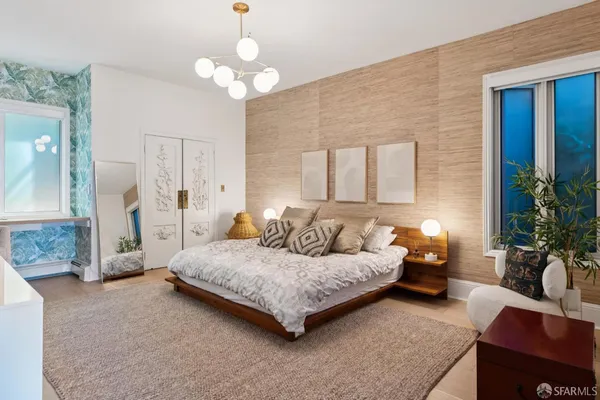 a bedroom with a bed couch and potted plant