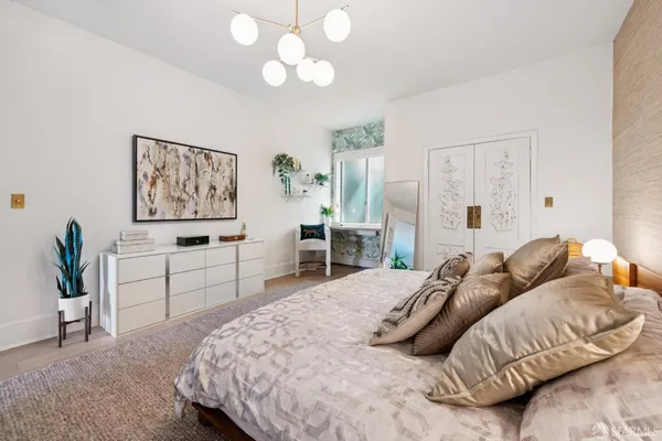 a bedroom with a large bed and a chandelier
