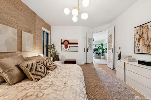 a spacious bedroom with a bed and a flat screen tv