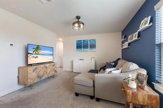 a living room with furniture a chandelier and a window
