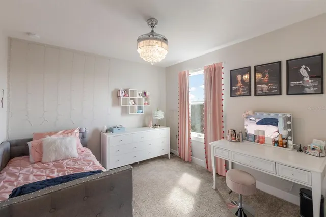 a bedroom with a large bed and a chandelier