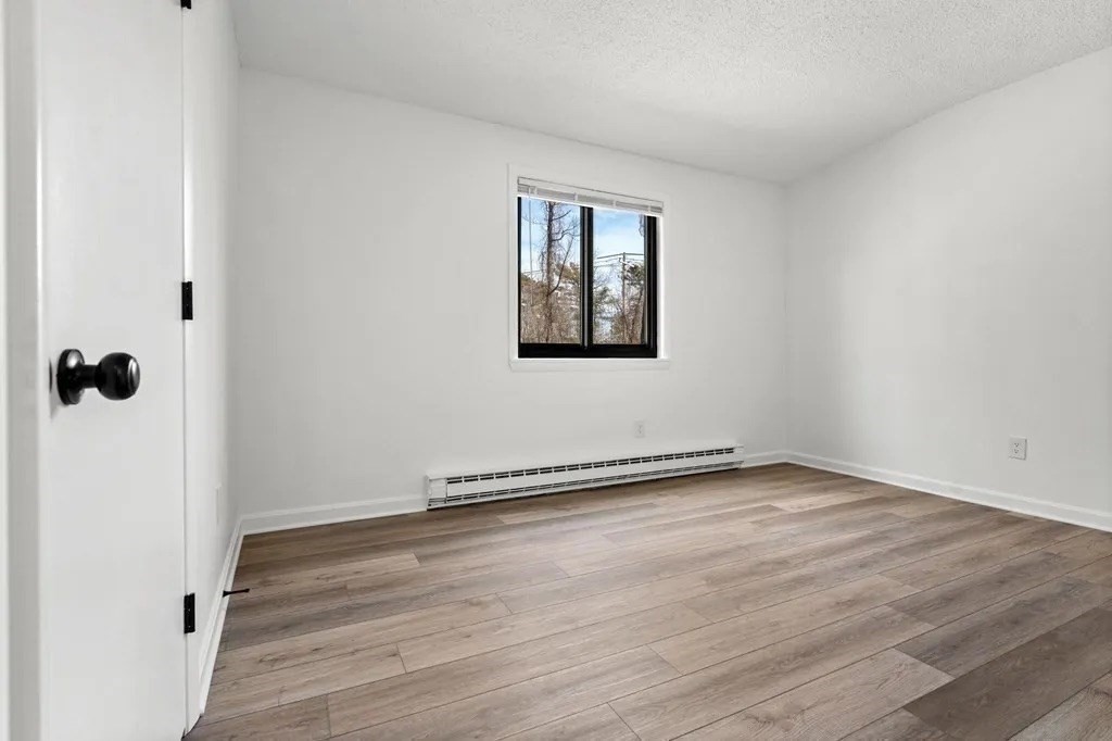 18 Pierce Street, Unit 3B Foxboro, MA 02035 - Photo 11 of 21 a view of an empty room with wooden floor and a window
